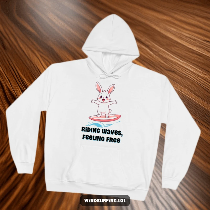 Funny rabbit windsurfer hoodie, depicting a cheerful hare in a comical balancing act on a windsurf board, arms spread wide.